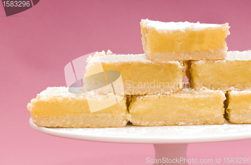 Image of Freshly baked lemon squares on a white cake stand