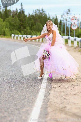 Image of Bride hitching on a road