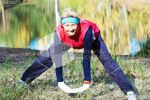 Image of Woman making of the stretching in full nature 