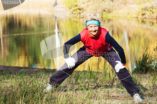 Image of Woman making of the stretching in full nature 