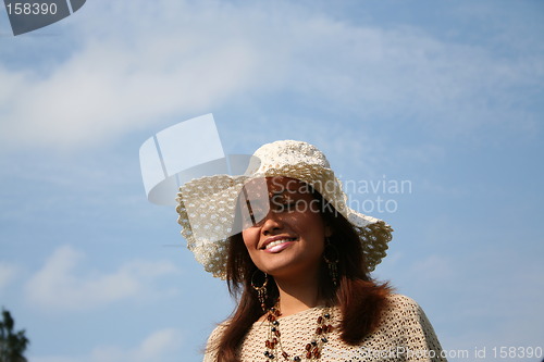 Image of Lovely girl in hat with the sky as background