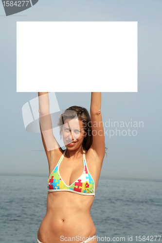 Image of A gorgeous model holding a blank sign in the air