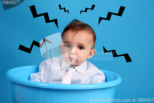Image of baby on a blue bucket, studio shoot, angry baby