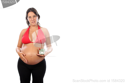 Image of young pregnant woman holding house model over white background 