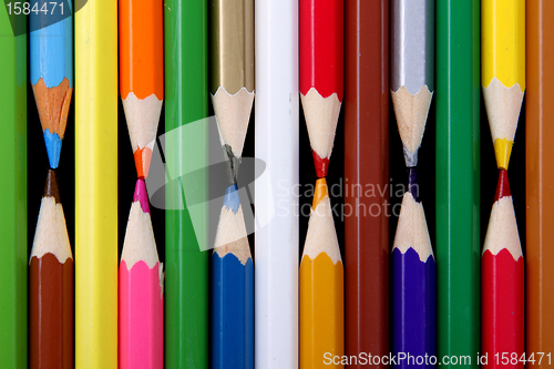 Image of Assortment of coloured pencils with shadow on white/back backgro