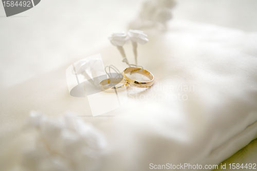 Image of Two wedding rings with white flower in the background, wedding p