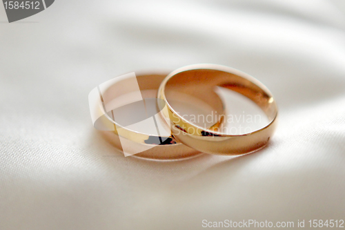 Image of Two wedding rings with white flower in the background, wedding p