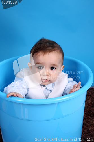 Image of Portrait of a happy baby boy on blue bucket isolated on blue bac