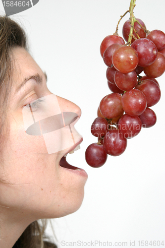 Image of beautiful woman with red grapes, healthy food