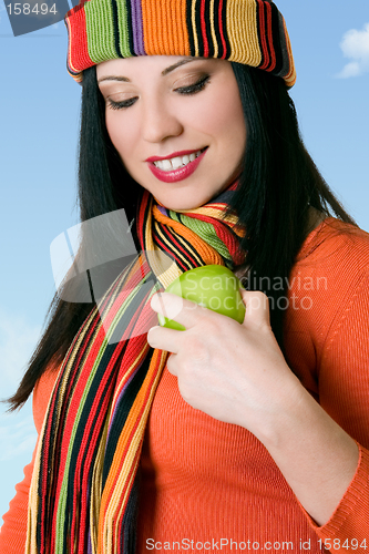 Image of Attractive female shining a fresh apple