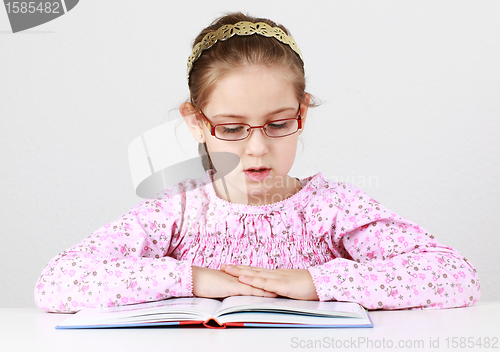 Image of Schoolgirl with glasses reading book