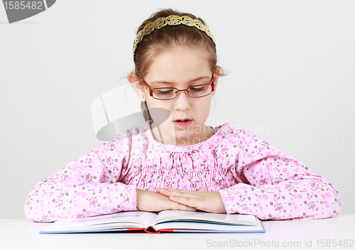 Image of Schoolgirl with glasses reading book