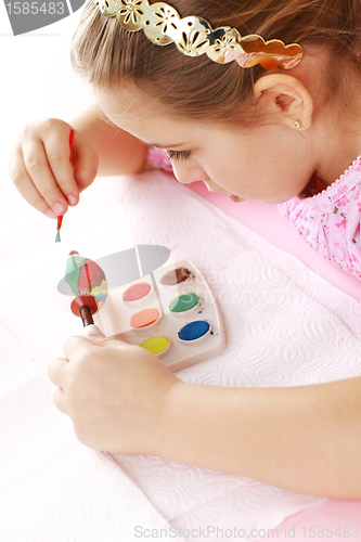 Image of Child painting Easter eggs