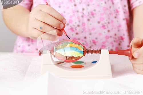 Image of Child painting Easter eggs