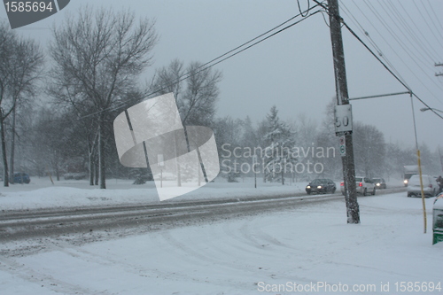 Image of Picture taken during a winter storm that passed by the city - cars and trucks slow because of the snow and sleet on the busy street