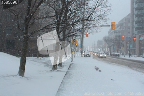 Image of Picture taken during a winter storm that passed by the city - cars waiting, red traffic light 