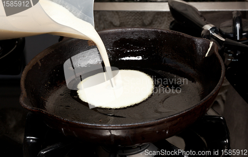 Image of Pouring pancake mix into frying pan