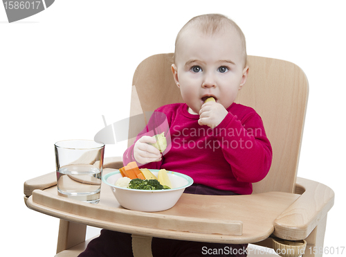 Image of young child eating in high chair