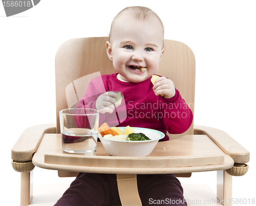 Image of young child eating in high chair