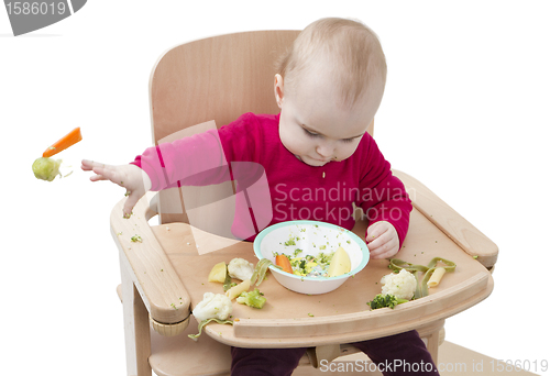 Image of young child eating in high chair