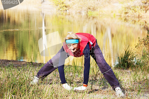 Image of Woman making of the stretching in full nature 