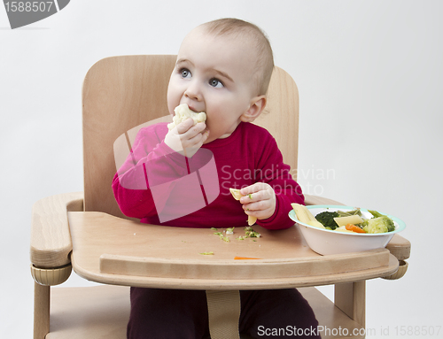 Image of young child eating in high chair