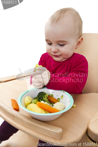 Image of young child eating in high chair