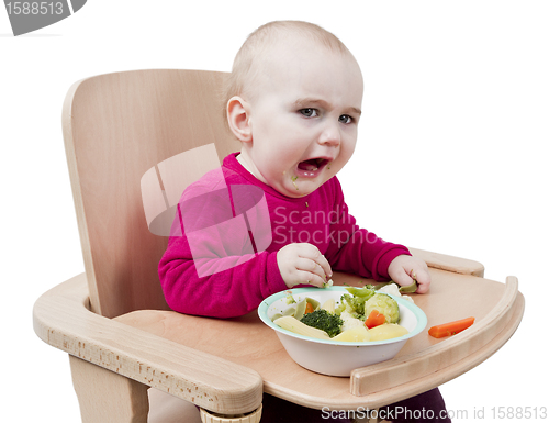 Image of young child eating in high chair