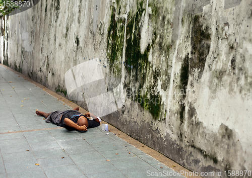 Image of Homeless Man bundled sleep in a city doorway