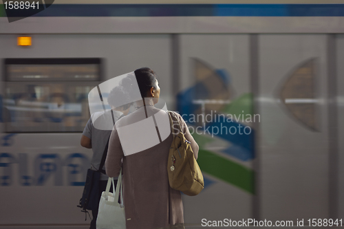 Image of woman and a train passing by