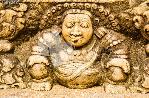 Image of stone statues that support the arch of steps, leading to a holy 