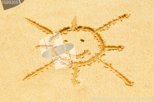 Image of Smiling sun drawn on a sandy beach