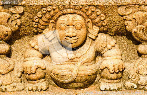 Image of stone statues that support the arch of steps, leading to a holy 