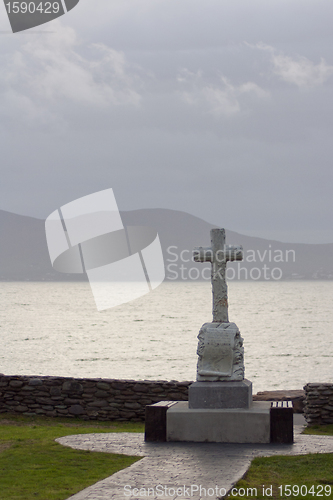 Image of A celtic cross in front of a Irish scenery