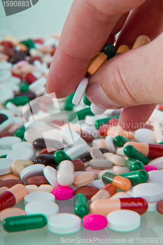 Image of hand grabbing pills