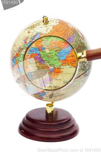 Image of Iran, Iraq and Afghanistan on the globe under a magnifier. 