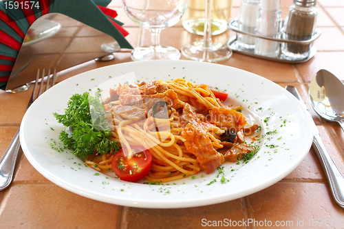 Image of Spaghetti with a tomato sauce on a table in cafe