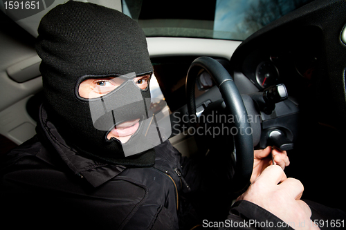 Image of robber and the thief in a mask hijacks the car