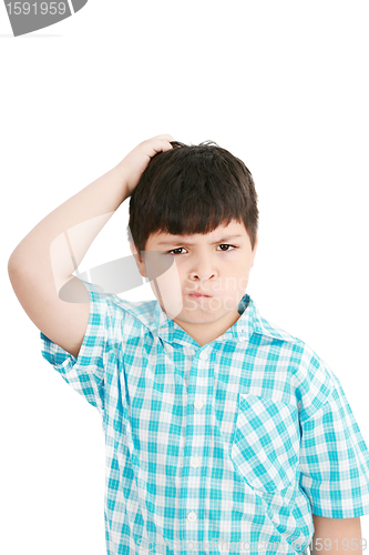 Image of Boy scratches his head in puzzlement or confusion, as if ponderi