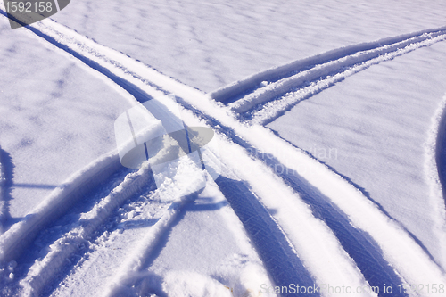 Image of tire tracks in the snow in winter