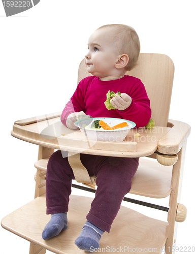 Image of young child eating in high chair