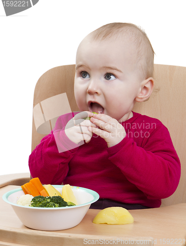 Image of young child eating in high chair