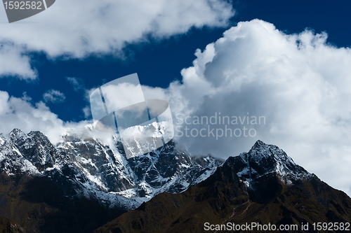 Image of Snowed up mountain range and clouds in Himalayas