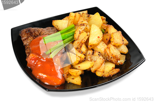 Image of Grilled meat and  fried  potatoes  on a plate