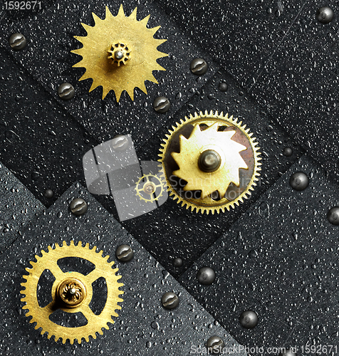 Image of Gold gears against ferrous metal
