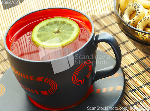 Image of Cup of tea with a lemon on a table 