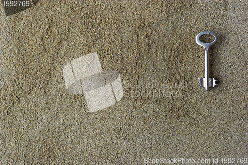 Image of Iron key on a concrete wall 