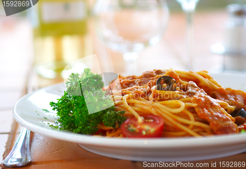 Image of Spaghetti with a tomato sauce on a table in cafe