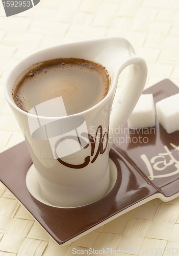 Image of choco latte. A white cup of coffee on a support. 