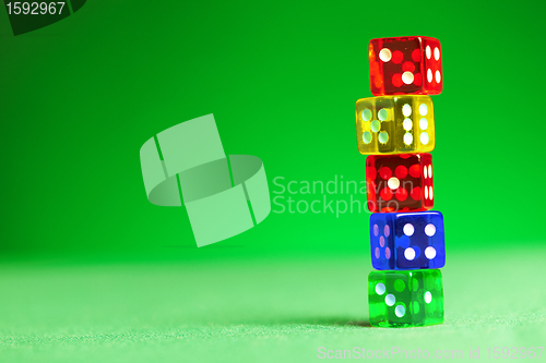 Image of multicolored dices on green cloth